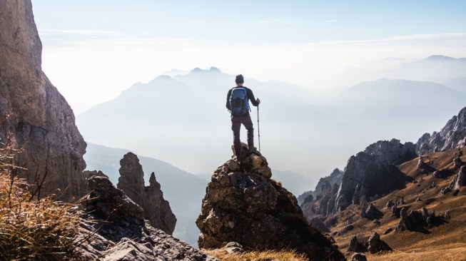 Climber enjoys the view from the top of the mountain